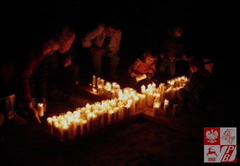 Plonące świece na przyniesionym przez młodzież pod ołtarz z relikwiami drewnianym krzyżu